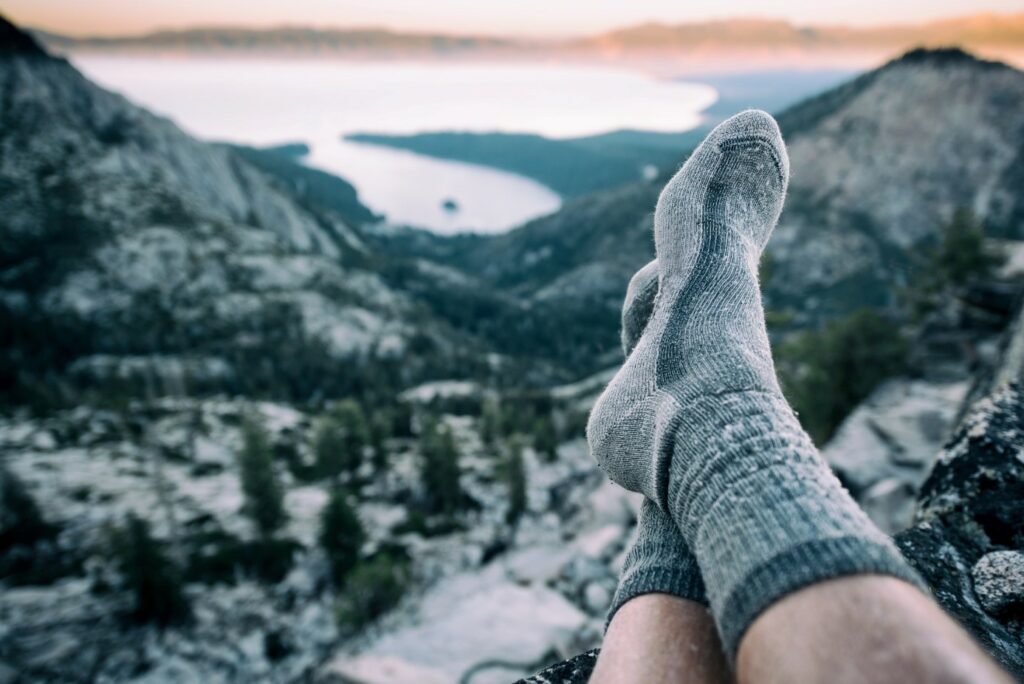 Prikaz predivnog pogleda s vrha planine i muških čarapa za planinarenje.