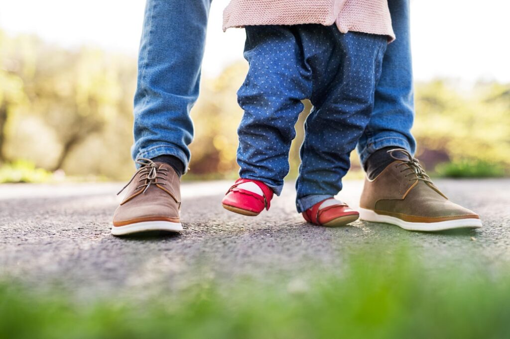 Dijete uči hodati u novim crvenim cipelama