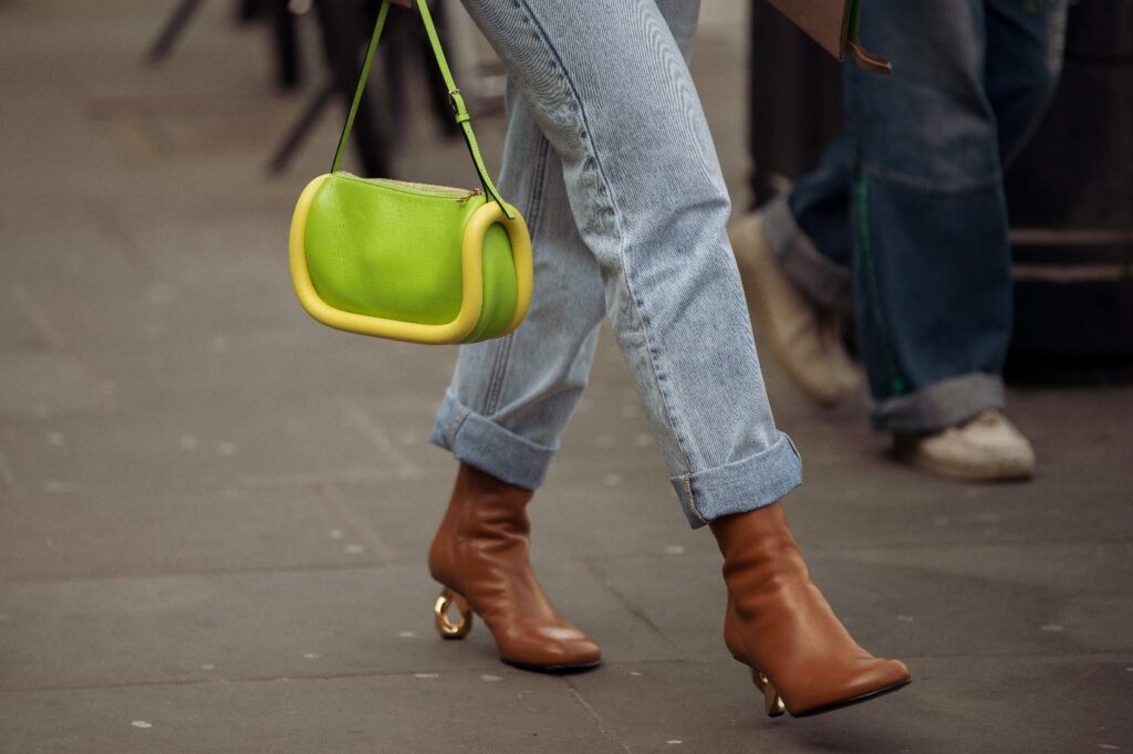 Smeđe čizme u kombinaciji sa zelenom torbicom i trapericama.